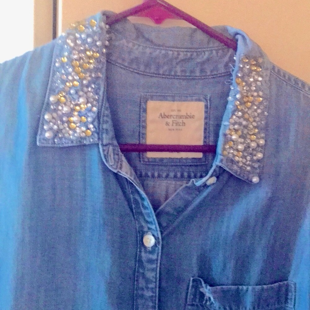 Sleeveless button down light blue denim shirt with beaded details